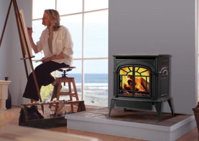 Wood stove burning while woman paints