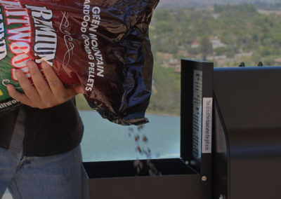 Man dumping pellets into a grill
