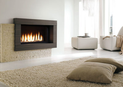 Gas burning fireplace insert in a large white room