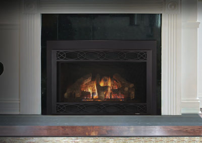 Gas insert fireplace burning in a white living room